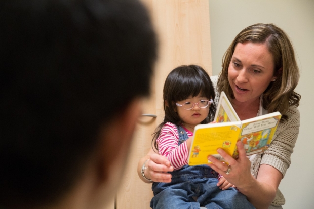 Dr. Casey Krueger reads to a child in the DBP clinic.